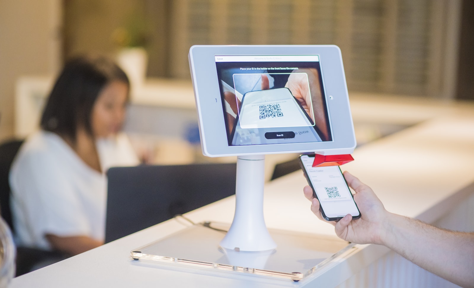 QR code check-in kiosk scanning a visitor's mobile ticket at event registration