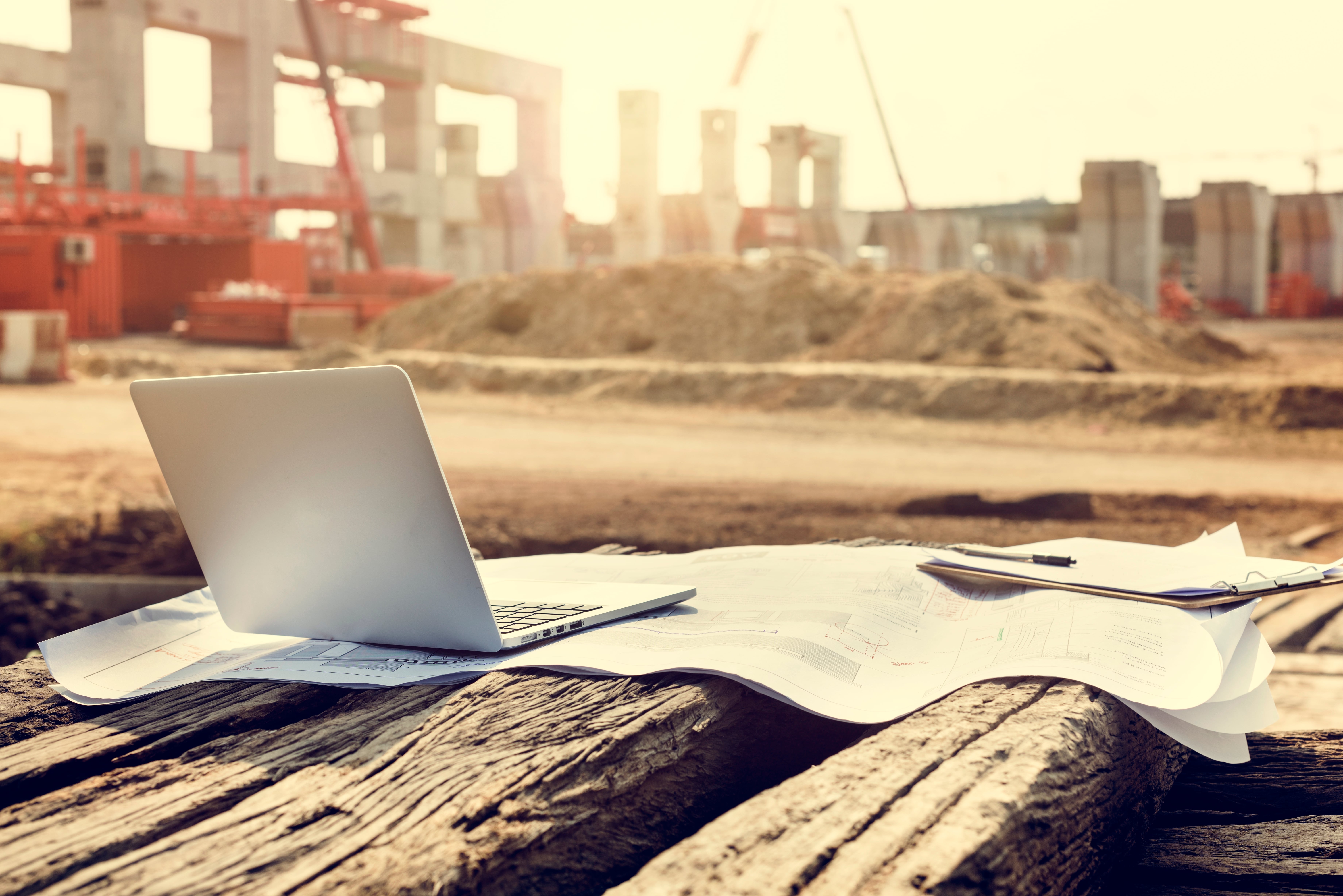 Laptop and blueprints on a construction site